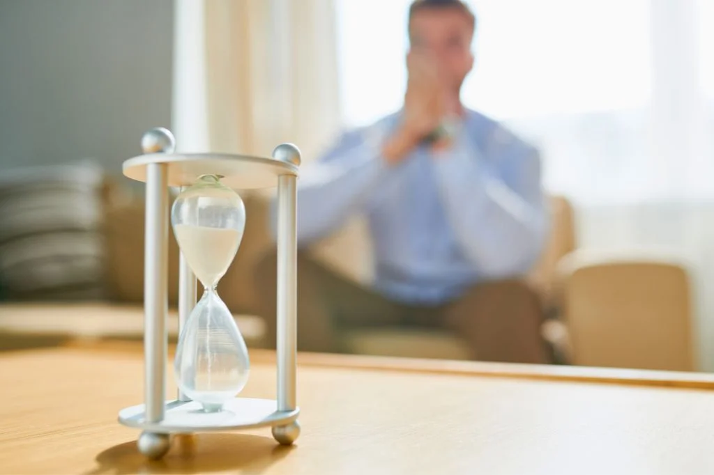 A worried person checking the time, anxious about the timeline for STD symptoms.