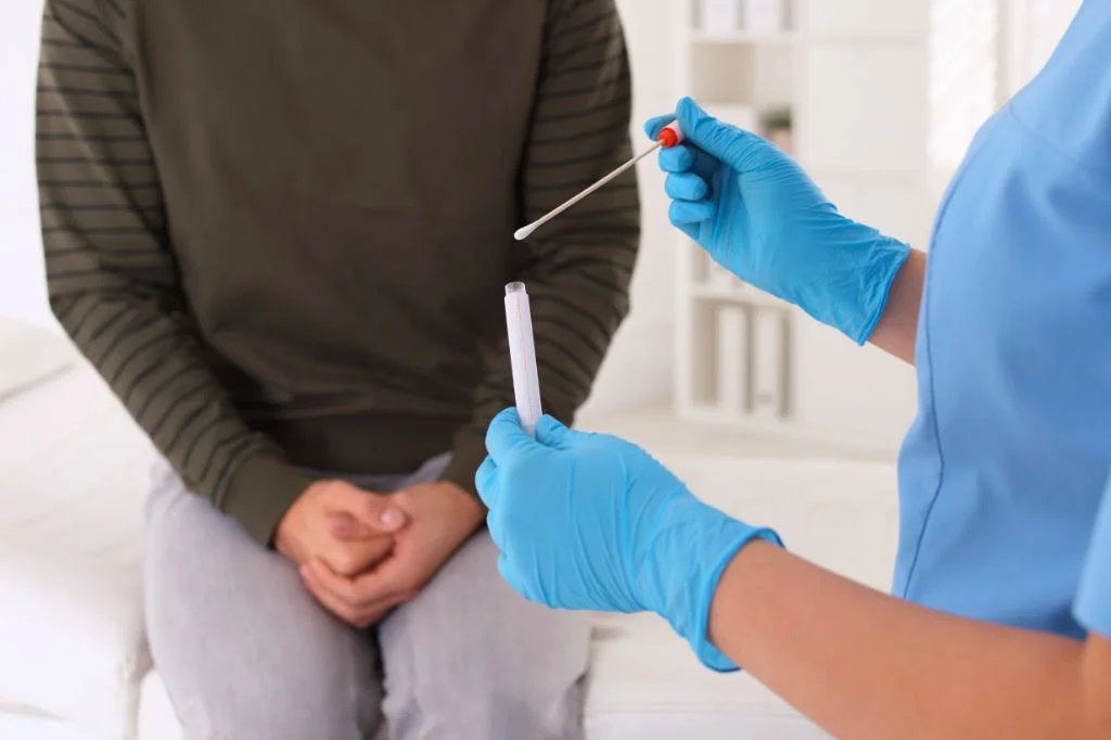 A doctor preparing a professional rectal swab test kit at a Bali clinic.