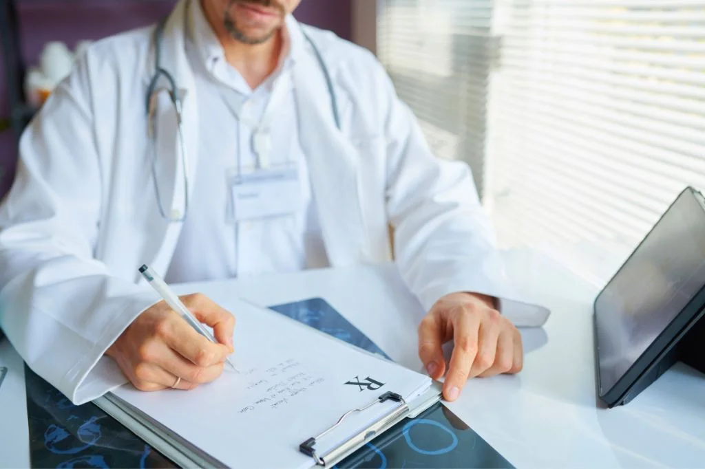 A doctor writing a prescription for STD medication in a Bali clinic.