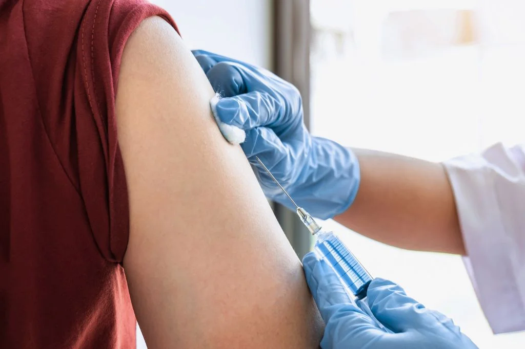 A doctor at a Bali clinic preparing a vaccine, such as the HPV or Hepatitis B vaccine.