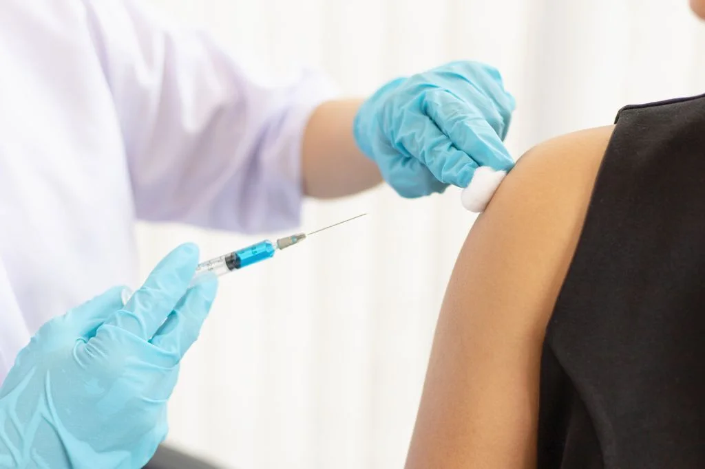 A doctor at a Bali clinic preparing a vaccine, such as the HPV or Hepatitis B vaccine.