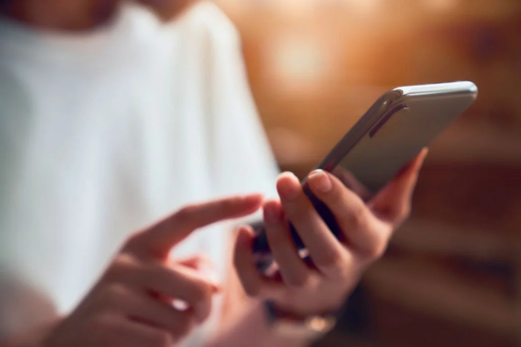 A patient receiving confidential medical results privately via smartphone in Bali.