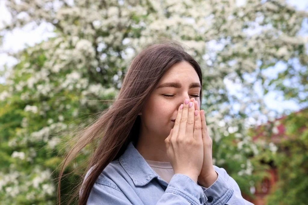 A tourist suffering from allergic rhinitis symptoms like constant sneezing and runny nose in Bali.
