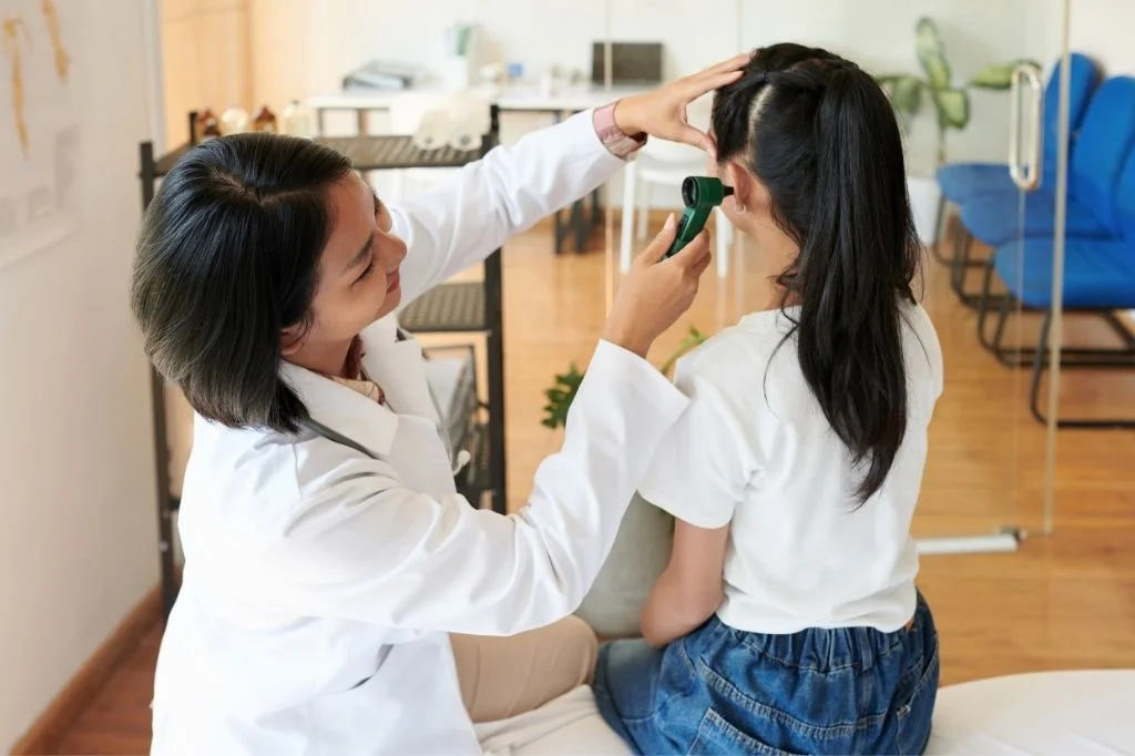 Hydro Medical doctor examining a patient's ear to diagnose labyrinthitis or otitis media.