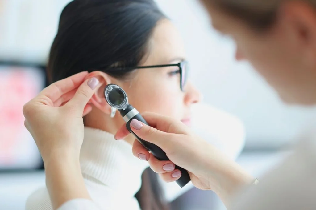 Hydro Medical doctor examining a patient's ear for signs of barotrauma or fluid.