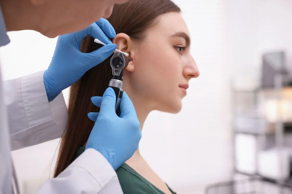 Hydro Medical doctor examining a patient's ear to diagnose Otitis Media.