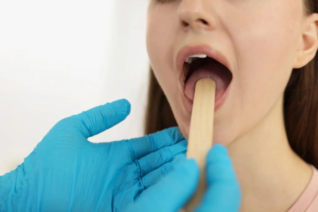 Hydro Medical ENT specialist examining a patient's throat to diagnose viral vs bacterial infection.
