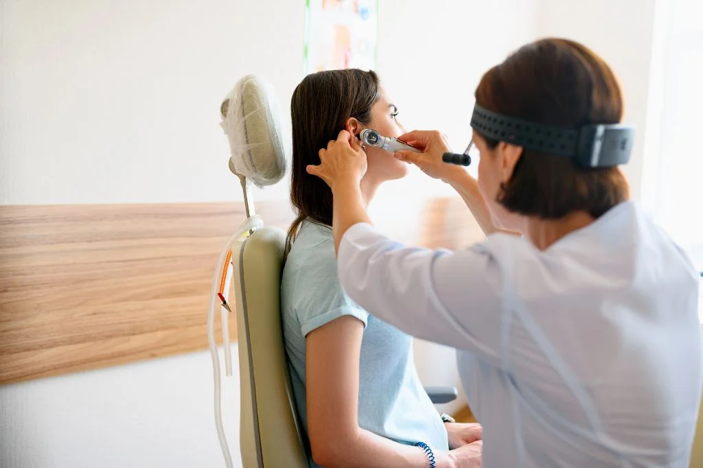 Hydro Medical ENT specialist examining a patient's ear using an otoscope in a modern clinic in Bali.