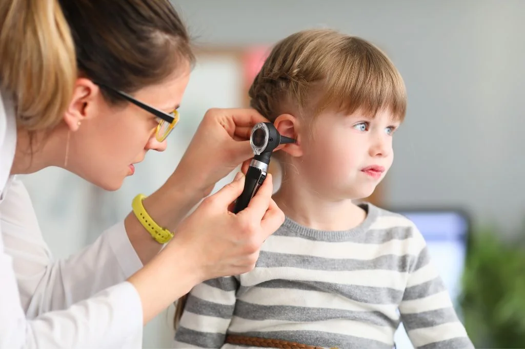 A toddler pulling their ear and crying, often mistaken for teething but could be an ear infection.