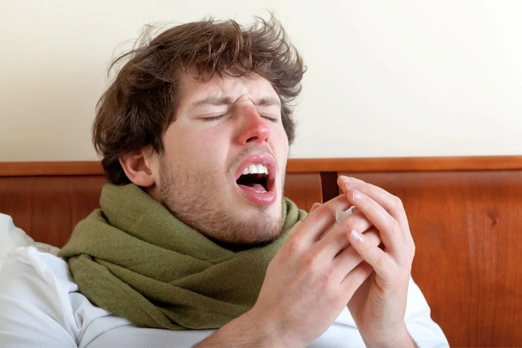A tourist experiencing facial pressure and pain, common symptoms of a Sinus Infection (Sinusitis).