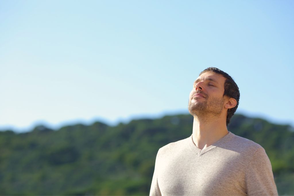 A traveler enjoying fresh air outdoors in Bali after successful nebulizer treatment for asthma.