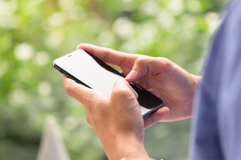 A tourist in Bali using a smartphone to book an ENT appointment via WhatsApp for quick medical assistance.