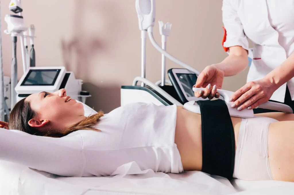 A medical professional placing the CM Slim HI-EMT applicator on a patient's abdomen for targeted muscle toning.