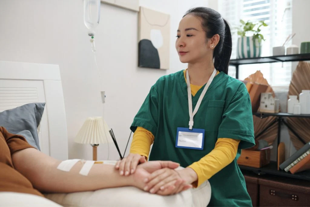 A medical professional preparing a vitamin-rich IV infusion for patient recovery.