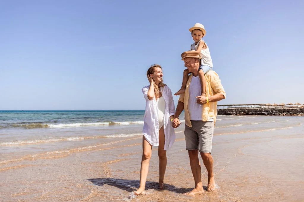 A family of three walking on the beach freely after getting a treatment from Hydro Medical Berawa