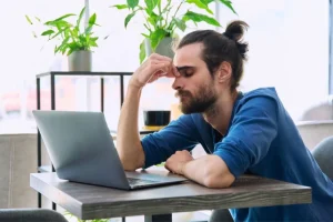 An expat in Bali struggling with a chronic headache while trying to work.