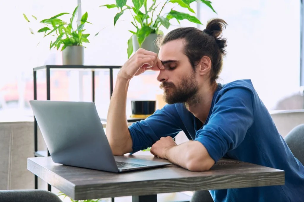 An expat in Bali struggling with a chronic headache while trying to work.