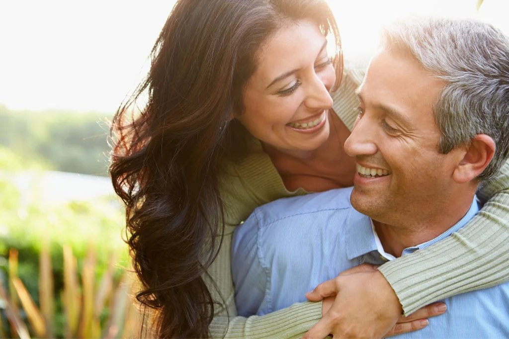 A happy couple enjoying an outdoor activity, looking fit and energized after their CM Slim treatment.