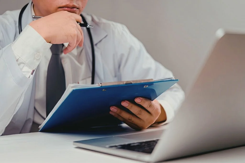 A doctor reviewing a patient's medical file to ensure continuity of care.