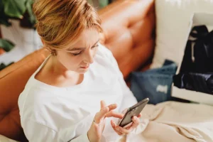 An expat looking concerned while researching health symptoms on a phone.
