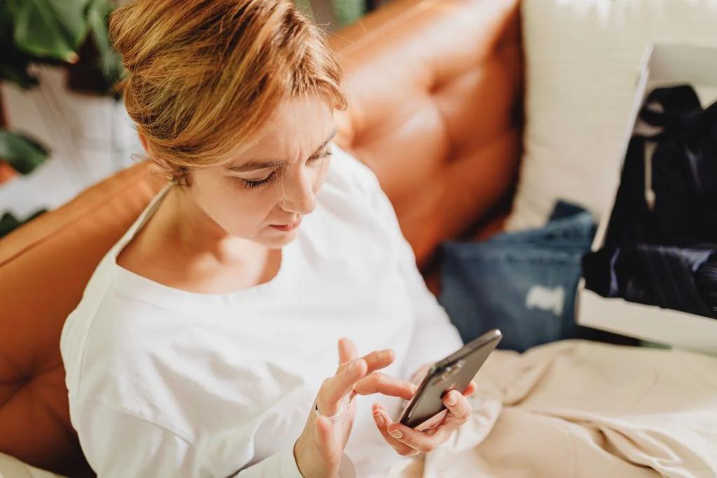 An expat looking concerned while researching health symptoms on a phone.
