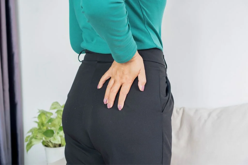 A person in Bali observing their anterior pelvic tilt, a poor posture condition that pushes the stomach forward to create a fake belly.