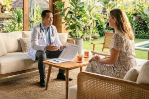 A professional internist conducting a home visit consultation in a private Bali villa.