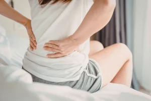 An expat in Bali experiencing lower back pain, a common sign of kidney issues or stones.