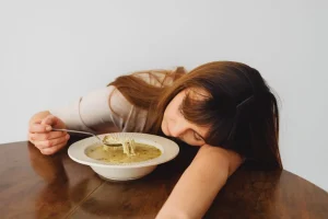 An individual experiencing fatigue after a meal, a potential sign of metabolic stress.