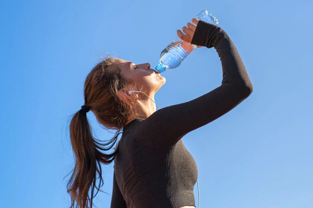 A fit person prioritizing deep hydration in Bali to help maximize the fat-burning results of their CM Slim treatment.