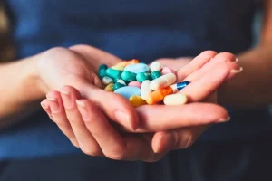 A person holding health supplements, representing a daily vitamin routine.