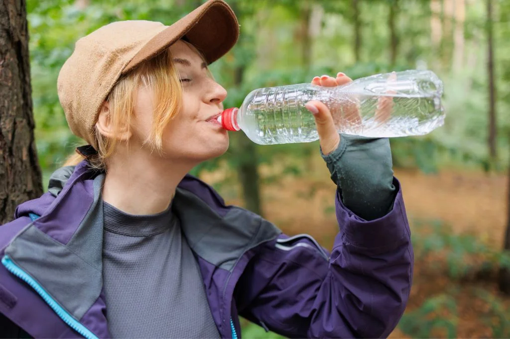 A person staying hydrated and resting after outdoor physical activity in a tropical climate.