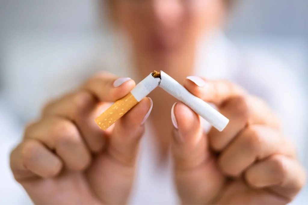 A traveler smoking outdoors in Bali, illustrating how vacation habits affect oral health.