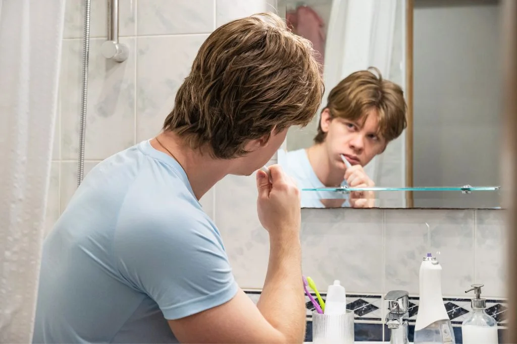 Concerned expat noticing bleeding gums after brushing in Bali.