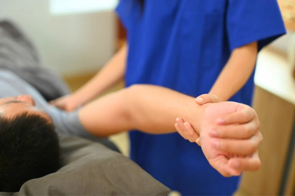 A professional physiotherapist assessing a patient's joint mobility at a Bali medical clinic.
