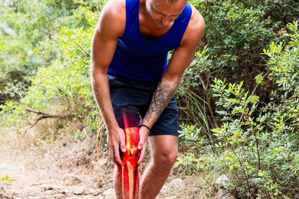 An active traveler in Bali checking their lower limb for chronic knee pain symptoms.