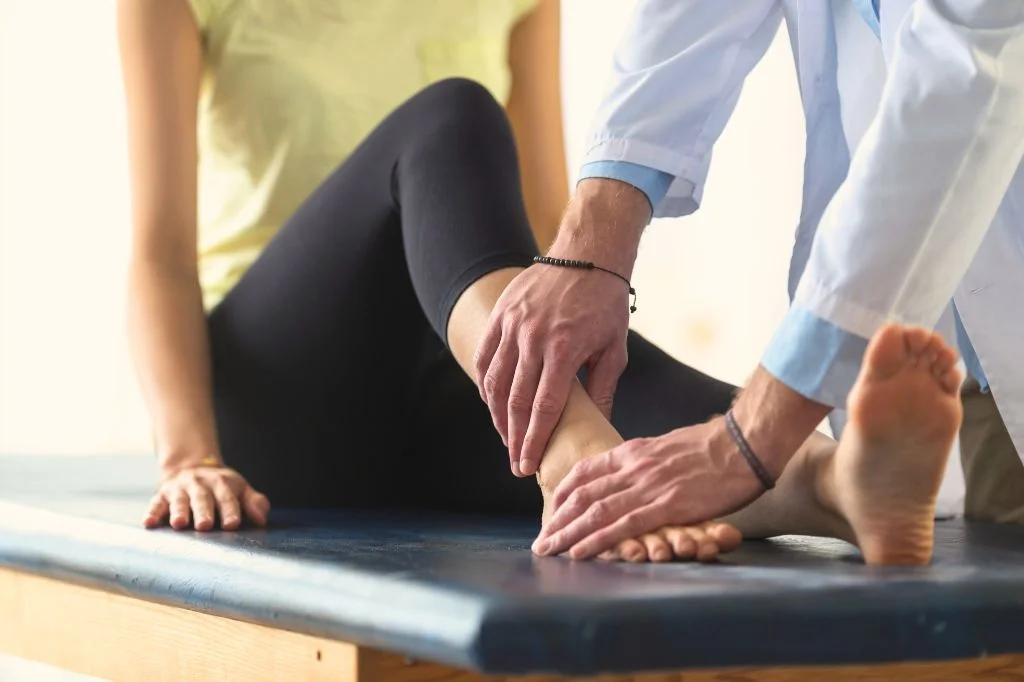A professional physiotherapist at Hydro Medical clinic performing an ankle assessment.
