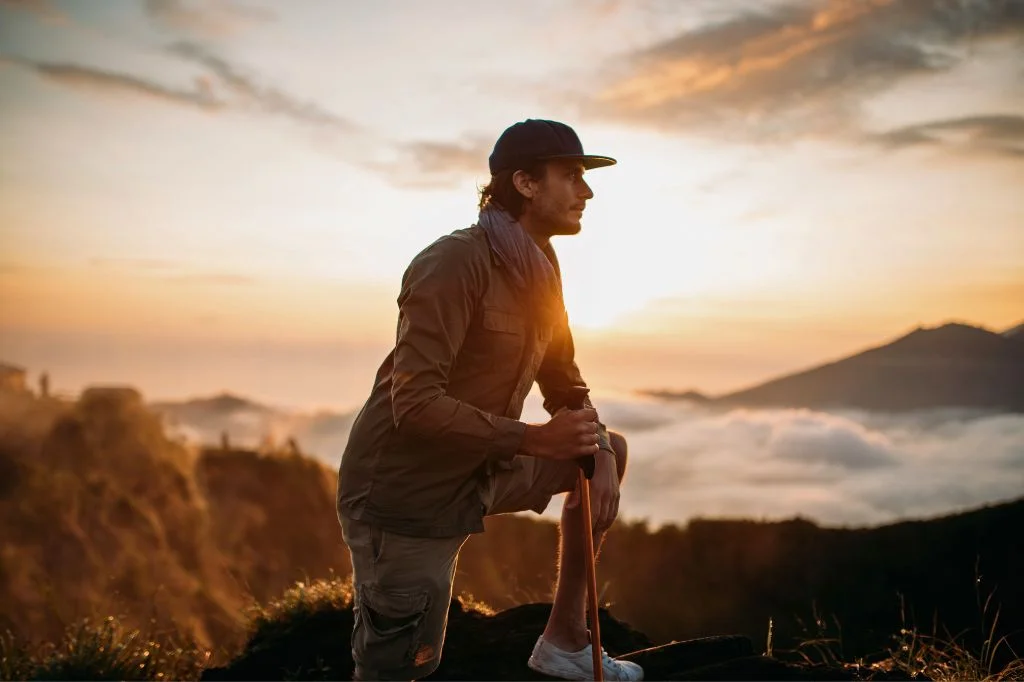 A happy tourist walking pain-free on a Bali mountain after successfully recovering from hiker's knee.