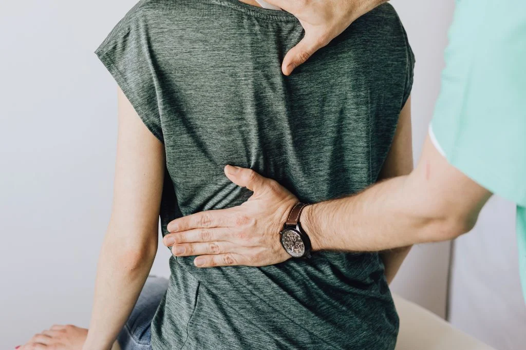 A physiotherapist at Hydro Medical Clinic Bali helping a patient with hip flexor stretches.