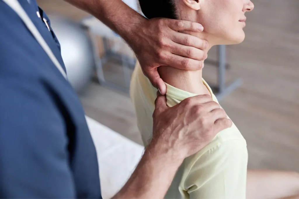 A clinical professional evaluating neck mobility in a patient after a minor scooter accident in Bali.