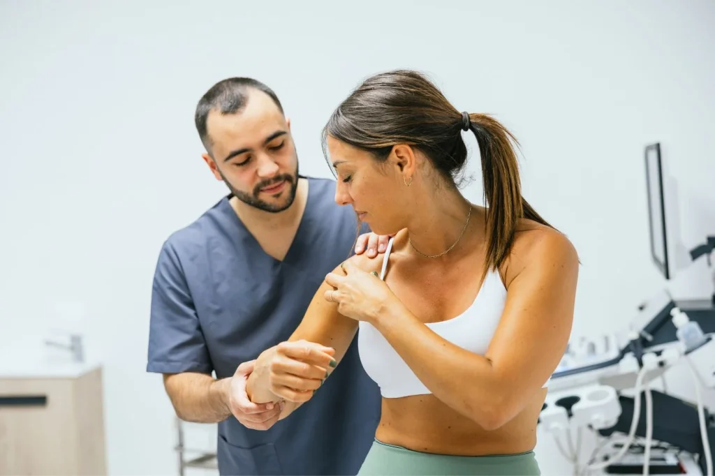 A professional physiotherapist helping a patient stretching the shoulder
