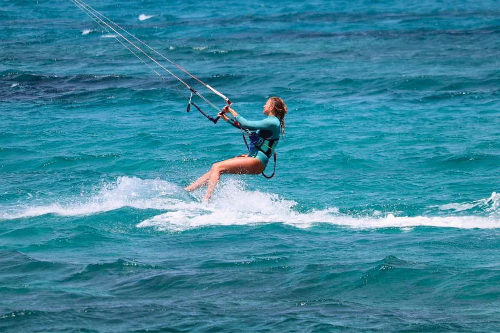 A kitesurfer in Sanur, Bali experiencing lower back pain after a long session on the water.