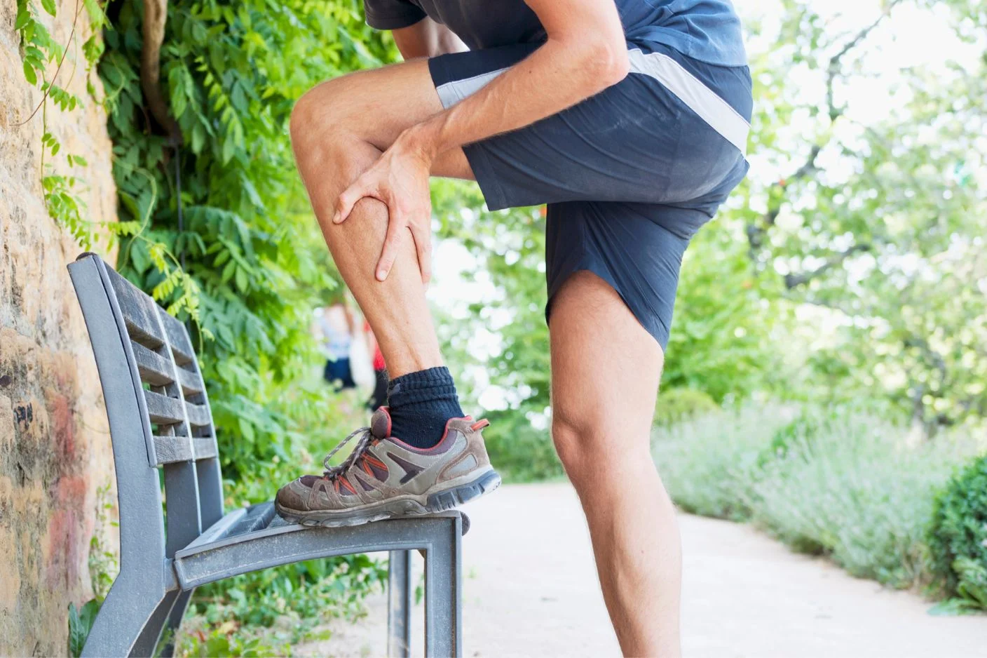 A traveler in Bali experiencing a sudden, severe muscle spasm on the beach after a workout.