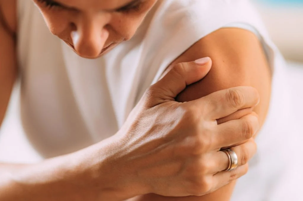 An individual waking up with severe shoulder stiffness linked to frozen shoulder in Bali.