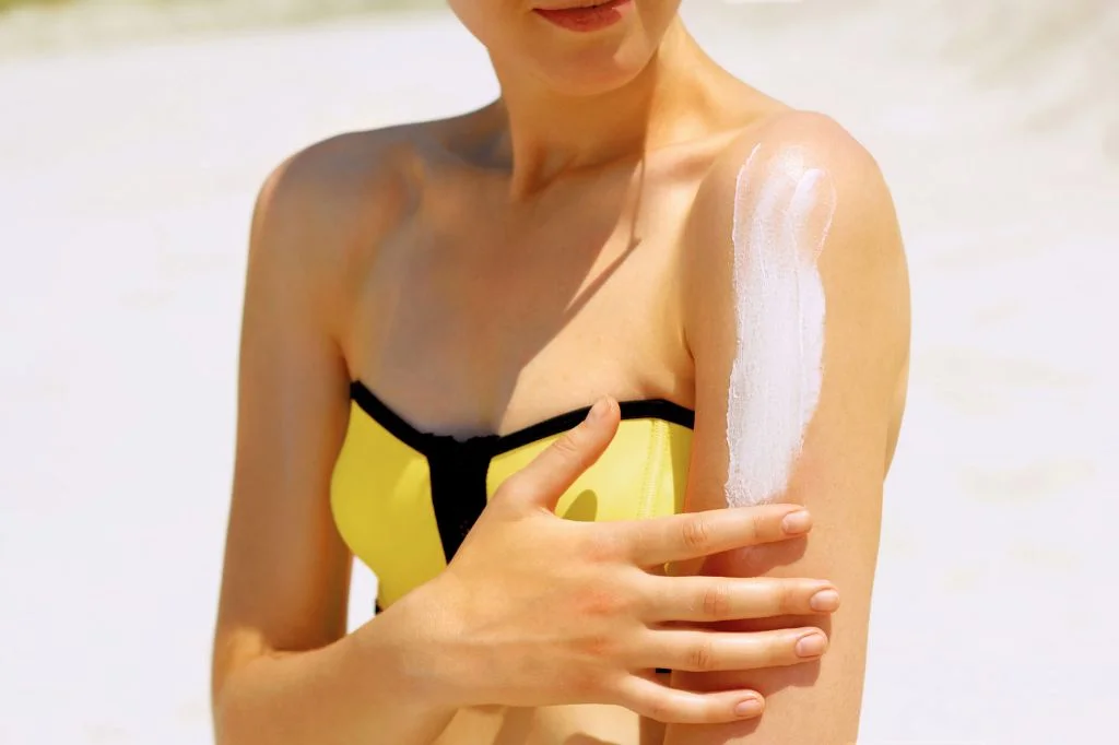 Traveler applying sunscreen before heading out in Bali, a common trigger for contact dermatitis