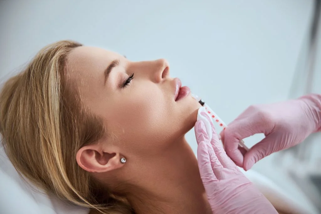 Dermatologist assessing lip and cheek proportions with a patient during a consultation in Bali