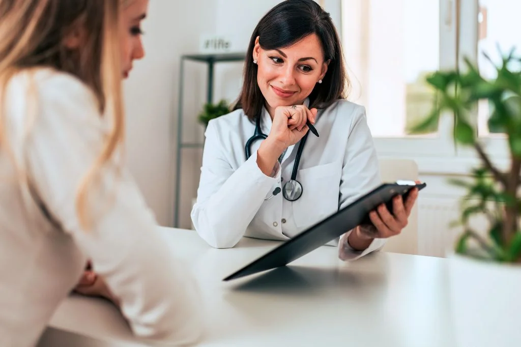 Dermatologist reviewing a treatment plan with a patient in a bright clinic room