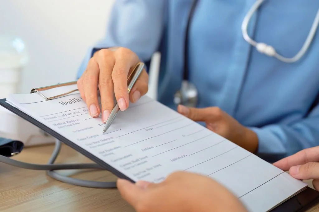 Dermatologist reviewing a patient's symptom history to identify a hives trigger