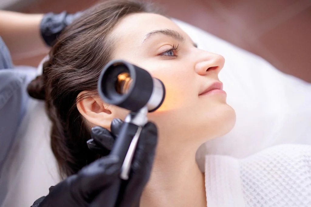 Dermatologist using a dermoscopy device to examine skin at a bright Bali clinic