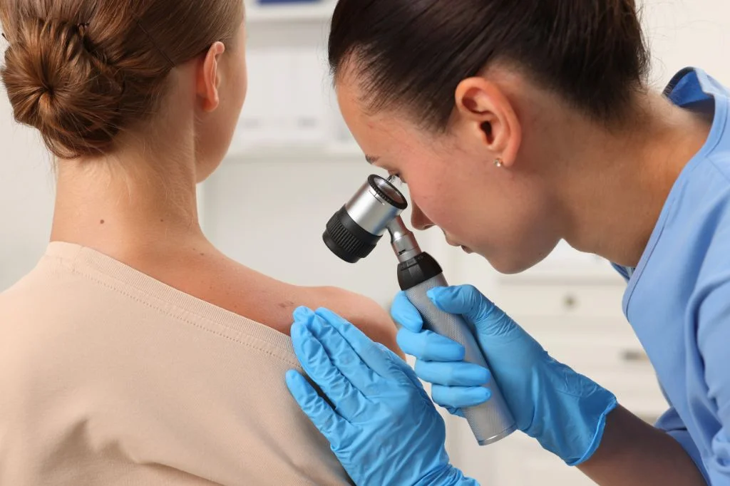 Dermatologist doing an examination to patient's mole in a clinic